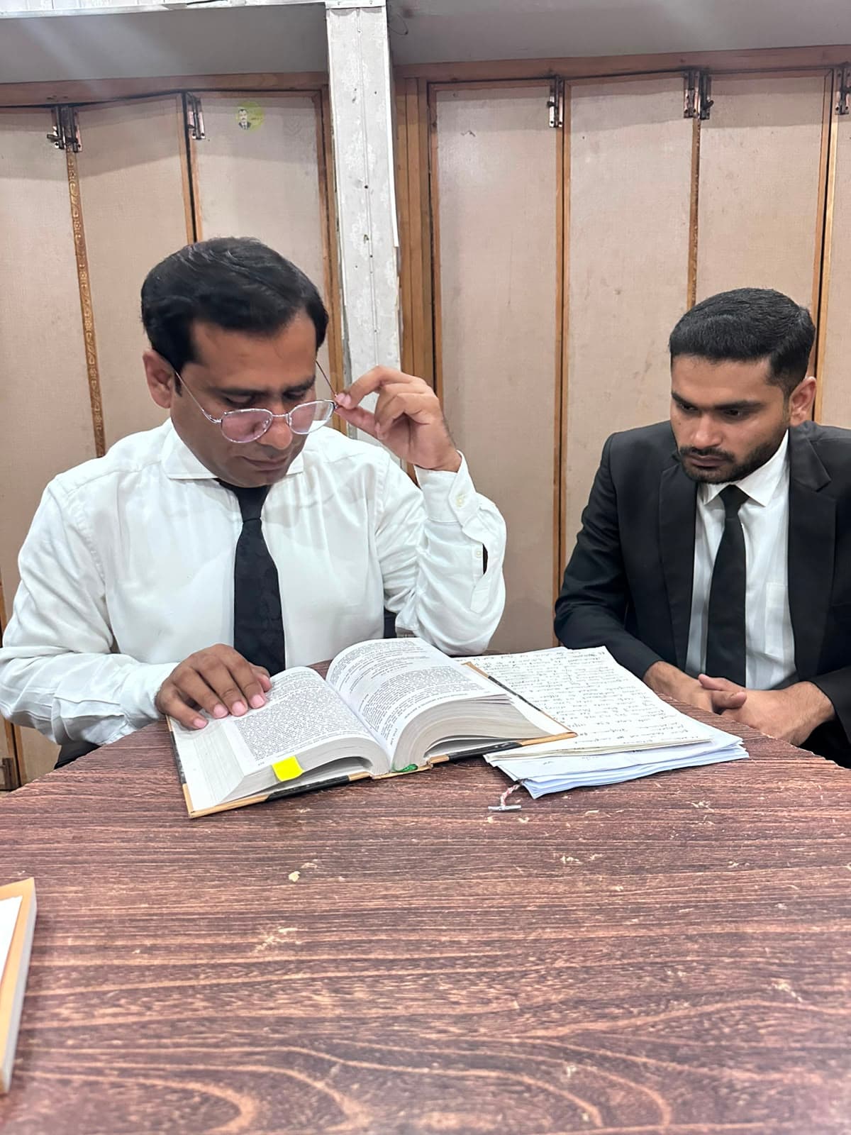 Advocates reviewing authorities and case papers at chambers